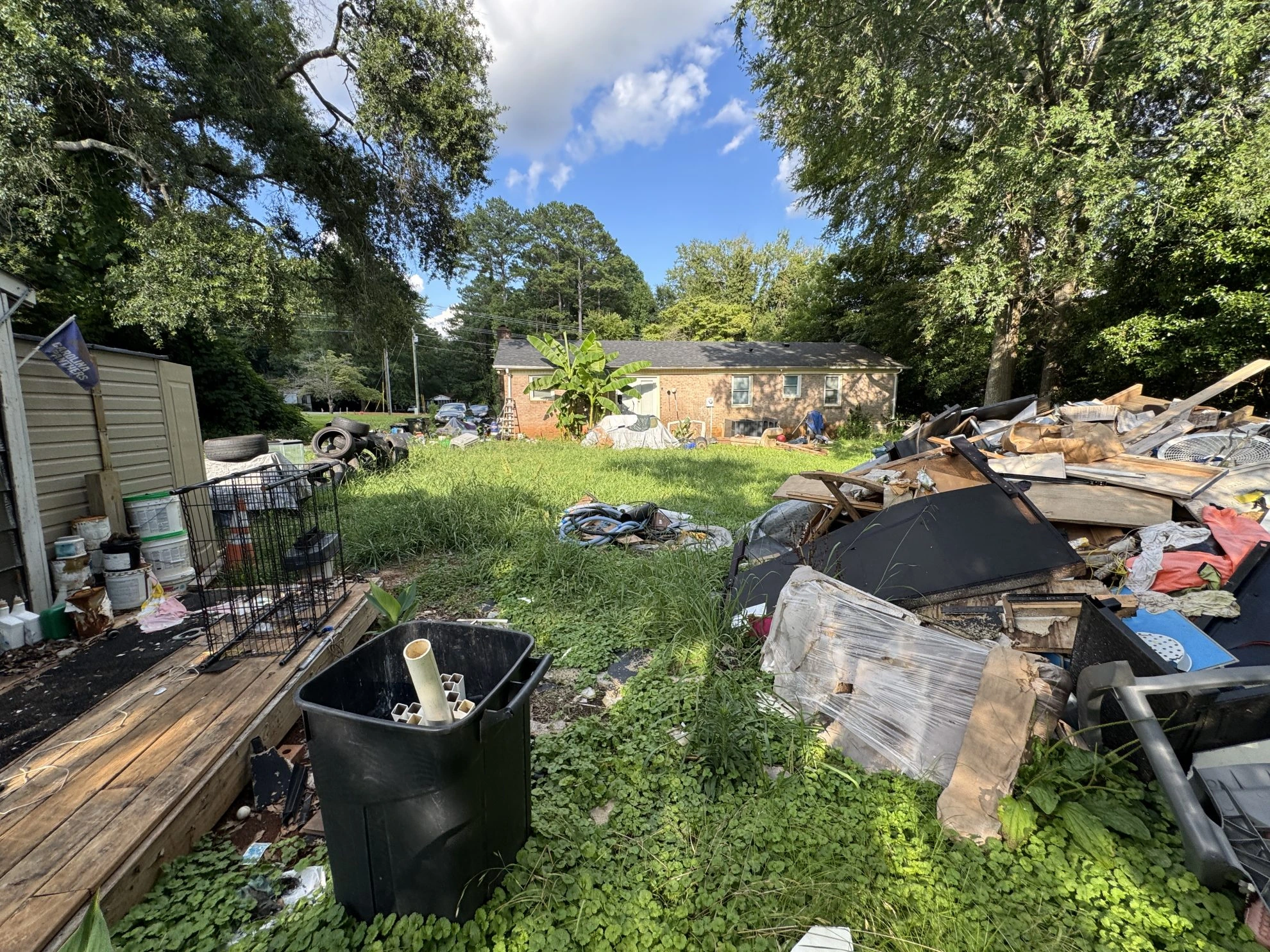 Distressed property with debris and overgrown yard in North Carolina eligible for as-is cash home sale